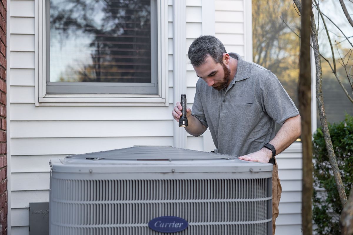 Technician servicing an air conditioning unit